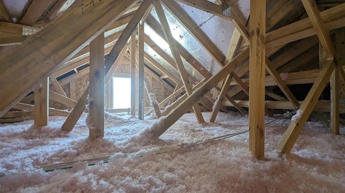 Fresh blown-in fiberglass insulation at full depth across an attic in Sunrise, FL